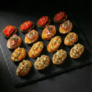 Premium Bruschettas mit Lachs-Tartar, Blauschimmelkäse und Schinken.