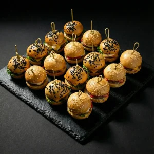 Burger Box »Hähnchen & Rind« mit 16 Mini-Burgern: Hähnchen mit Paprika und Bleu-Cheese-Sauce sowie Rind mit Cheddar und Trüffel-Mayonnaise – Moment Catering Stuttgart.
