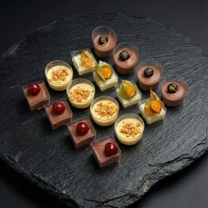 Dessert Box »Artisan Sweet Selection« mit 16 Gourmet-Desserts: Schokoladenmousse mit Kirsche, Zitronenmousse und nussige Kreationen.