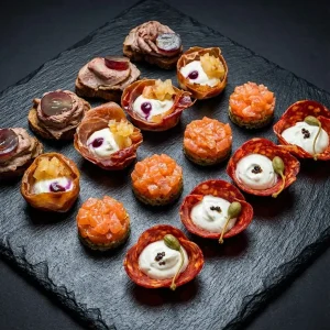 Gourmet Tapas Box mit Roastbeef Canapés, Chorizo Körbchen und Lachs Tatar.