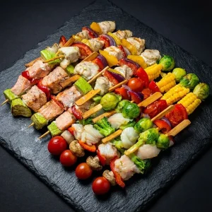 Grillspieß Box »Mixed Premium« von Moment Catering Stuttgart mit 20 gegrillten Spießen: Veggie (Rosenkohl, Mais, Paprika, Cherry, rote Zwiebel), Chicken (Paprika, Zwiebel), Lachs (Zucchini, Paprika) und Zander (Brokkoli, Rosenkohl, Champignon, Cherry) – ideal für BBQ, Buffet und Business-Events in Stuttgart (ca. 2.000 g).
