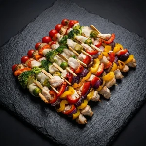 Grillspieß Box von Moment Catering Stuttgart mit 16 Grillspießen: gegrillter Wels mit Brokkoli, Paprika, Rosenkohl, Champignons und Cherry-Tomaten sowie gegrilltes Chicken mit Paprika, Rosenkohl und Krimzwiebel – servierfertig für BBQ, Buffet und Business-Events in Stuttgart (ca. 2.000 g).