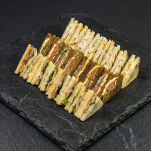 Sandwich Box »Premium Trio« mit 24 Sandwiches: Roastbeef-Cheddar, Lachs mit Omelett sowie Chicken mit Pfirsich und Gorgonzola – Moment Catering Stuttgart.