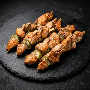 Spieß Box von Moment Catering Stuttgart mit Lachs-Zucchini-Spießen: zarter Lachs und saftige Zucchini, mariniert mit Sojasauce und Sesam, servierfertig für Fingerfood, Empfang und Business-Events in Stuttgart (ca. 1.000 g).