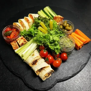 Veggie & Wrap Box von Moment Catering Stuttgart (ca. 1.200 g) mit Gemüse-Sticks (Karotte, Gurke, Sellerie, Cherry-Tomaten), Salatmix, gegrillten Oliven, ofenmarinierter Paprika, Auberginen-Mousse mit Tahini, Wrap-Rolls mit Lobio und Tomaten sowie asiatisch mariniertem Tofu – ideal für Meeting, Office-Lunch und Event-Catering in Stuttgart.
